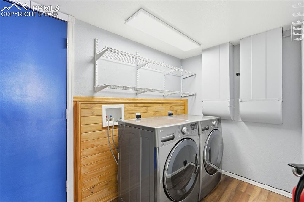 Image 34 of 45: Laundry room featuring wood finished floors and washing machine and dryer