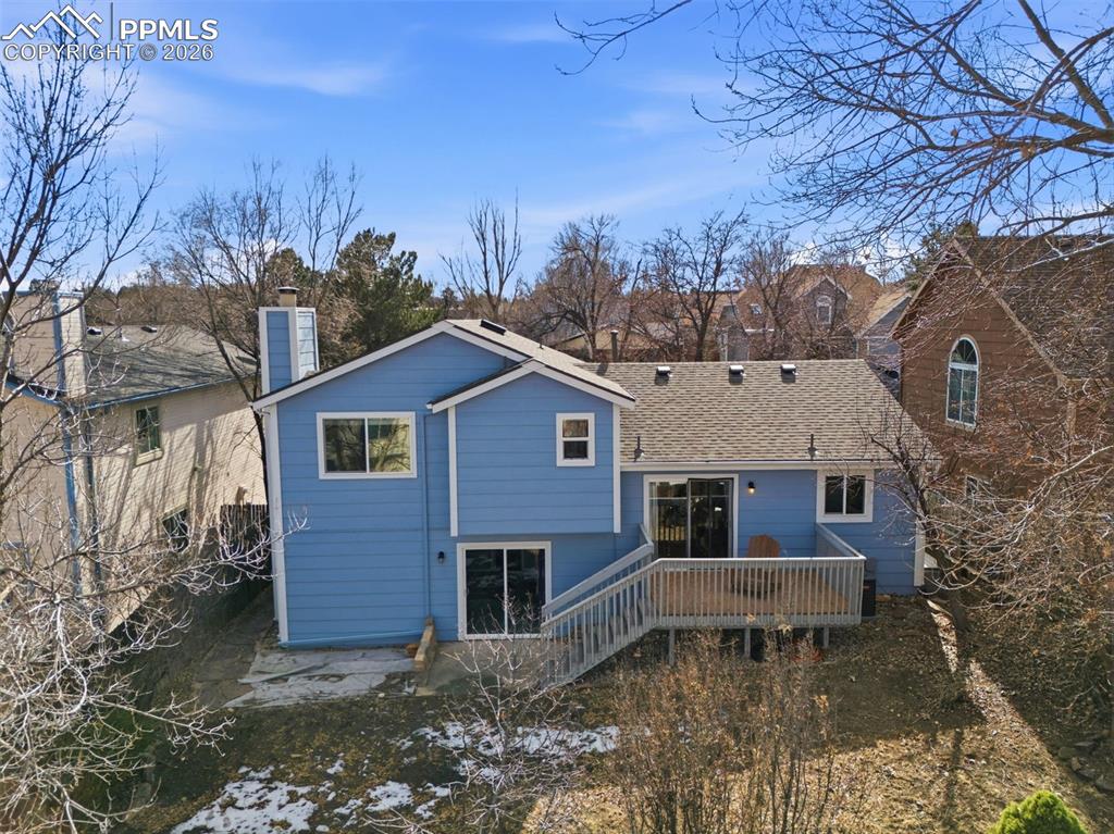 Image 39 of 45: Back of house with a deck, a chimney, and a shingled roof