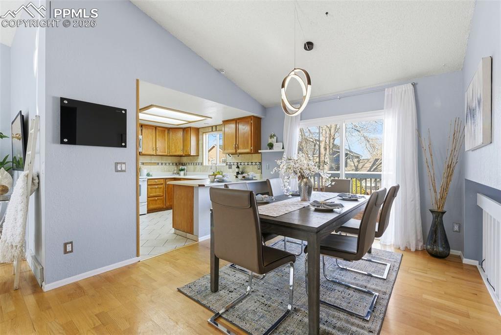 Image 6 of 45: Dining area featuring lofted ceiling and light wood-style floors