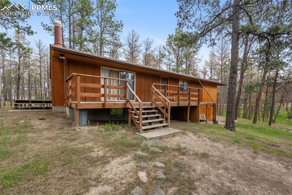 Caption: Front entry with a wood deck and sliding door access to the living room 