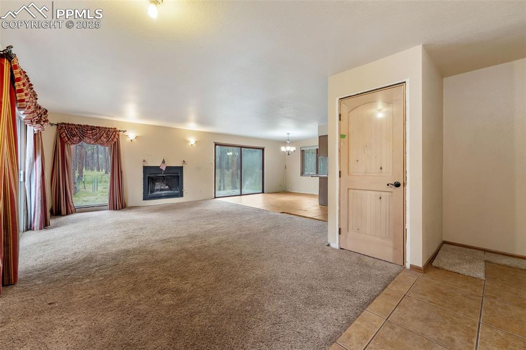Image 4 of 43: Main level living room with carpet
and wood burning fireplace