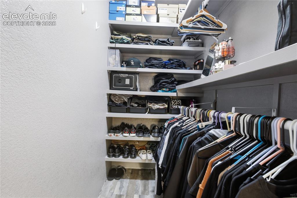 Image 20 of 30: SPACIOUS WALK-IN CLOSET WITH AMPLE SHELVES FOR STORAGE