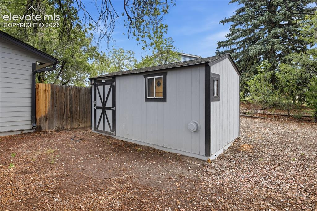 Image 30 of 30: STORAGE SHED IN BACKYARD.