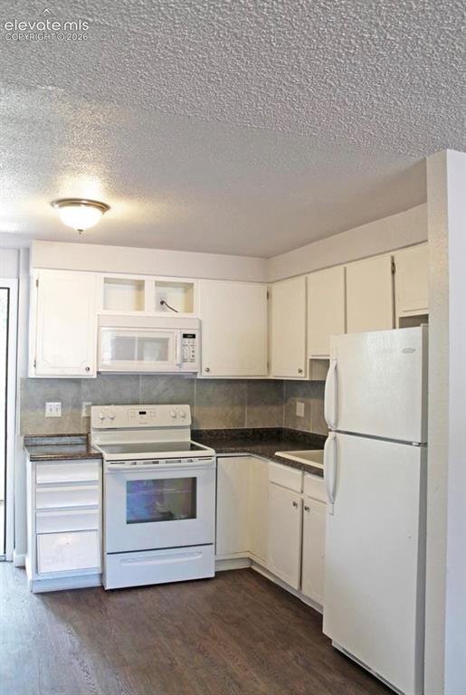 Image 7 of 12: Efficient galley-style kitchen featuring white cabinetry, stainless steel a