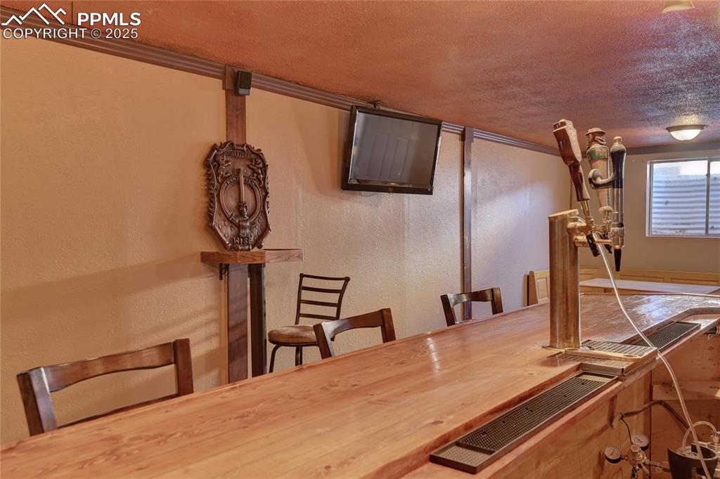 Image 33 of 37: Custom large bar in the basement with room for all your friends, beverages,