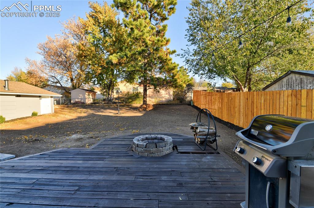 Image 36 of 37: Large back yard with fire pit on the deck