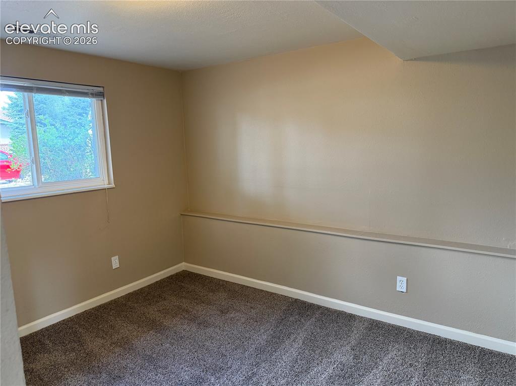 Image 13 of 17: Carpeted flooring, neutral wall tones, and a window with natural light in l