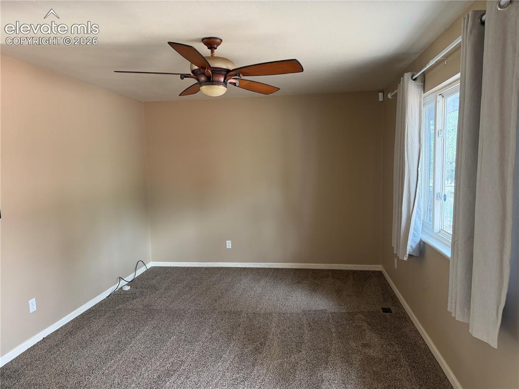 Image 3 of 17: Ceiling fan with integrated lighting, window with white trim, wall-to-wall