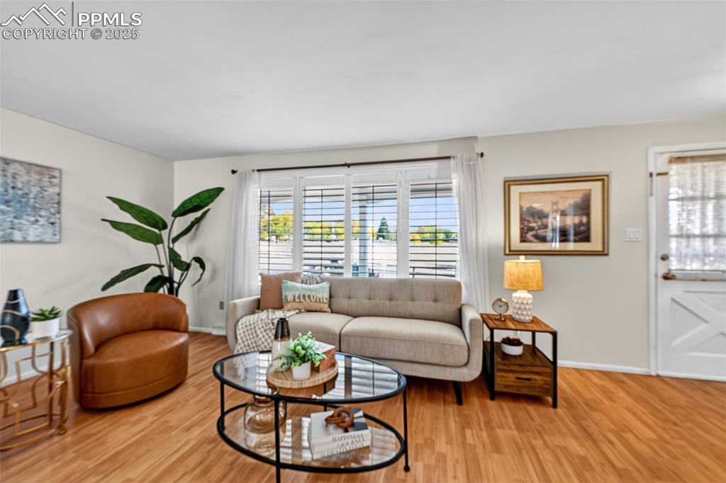 Image 8 of 40: Another view of the great room with wood look flooring and plantation shutt