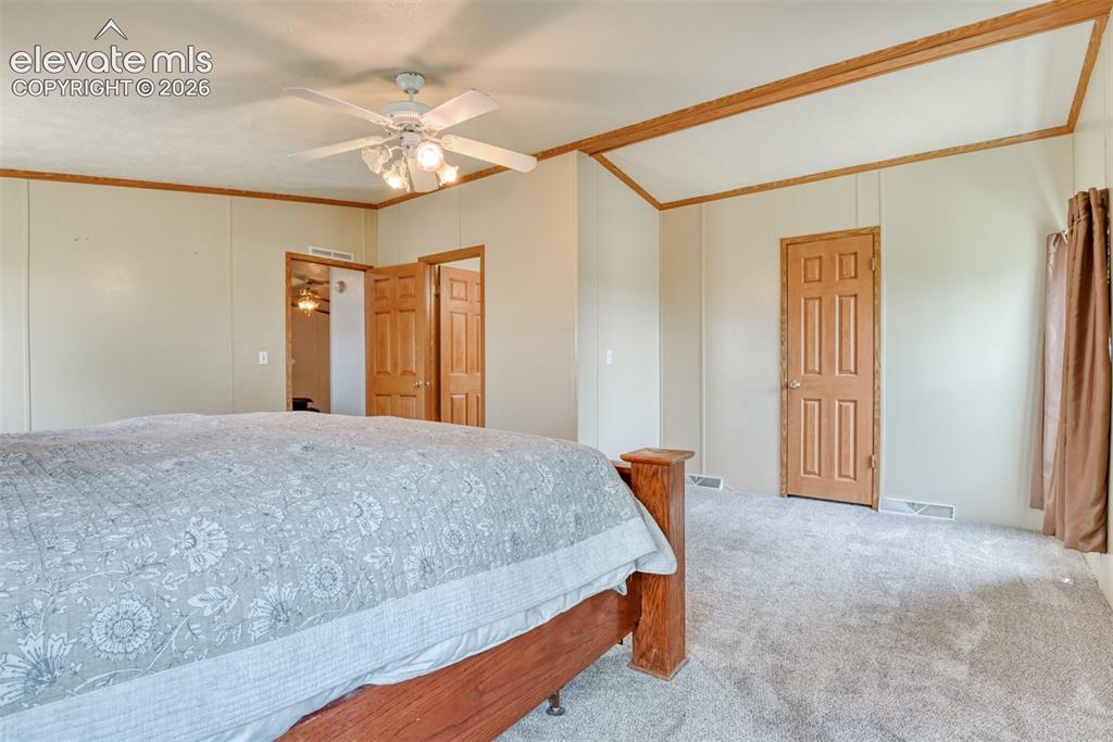 Image 13 of 50: Carpeted room featuring two windows with drapes, a ceiling fan with integra