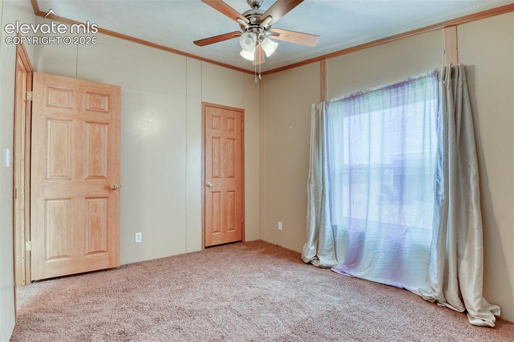 Image 25 of 50: Room featuring light-colored walls with wood trim, paneled doors, and textu