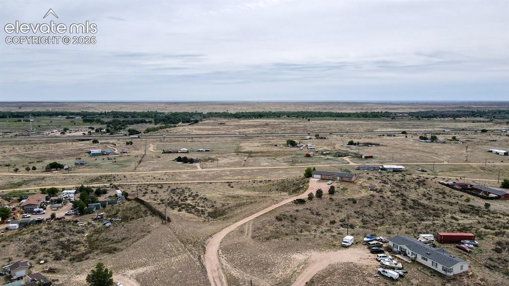 Image 32 of 37: Expansive undeveloped land featuring scattered residential structures and v