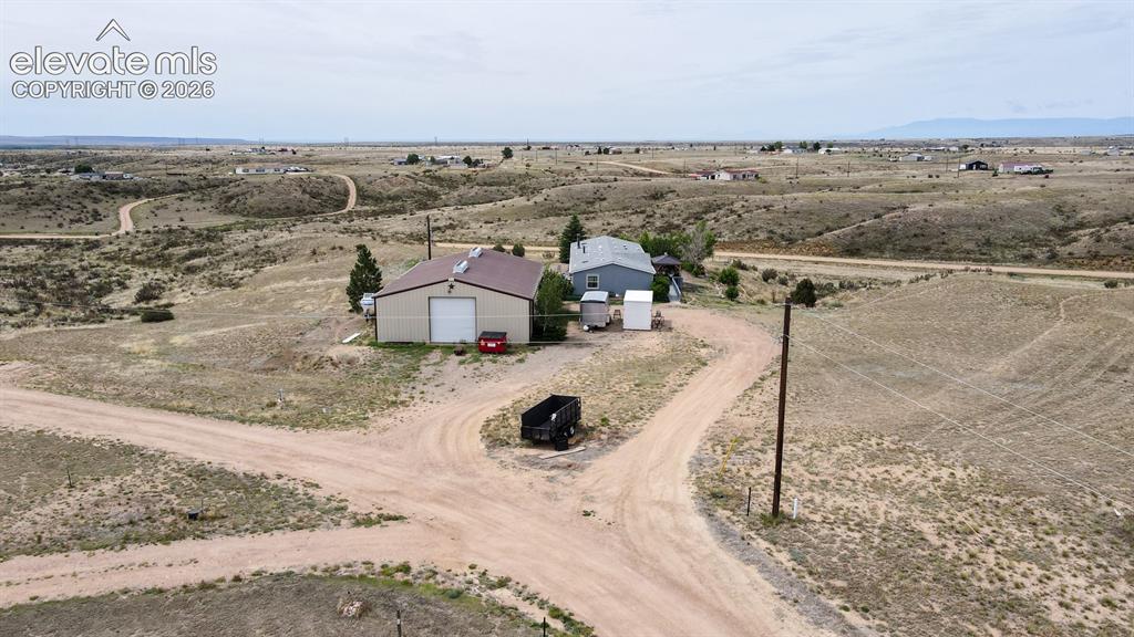 Image 33 of 37: Expansive rural property featuring a main residence, an outbuilding with a