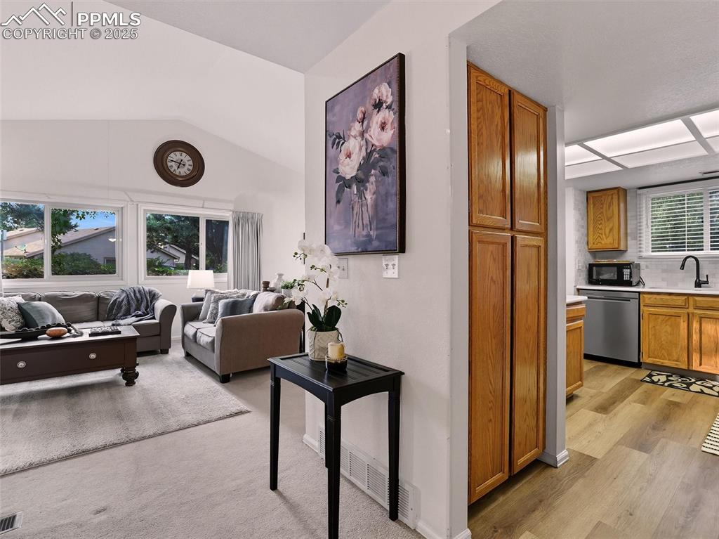 Image 22 of 36: Front foyer leads to living room and kitchen, including the kitchen pantry
