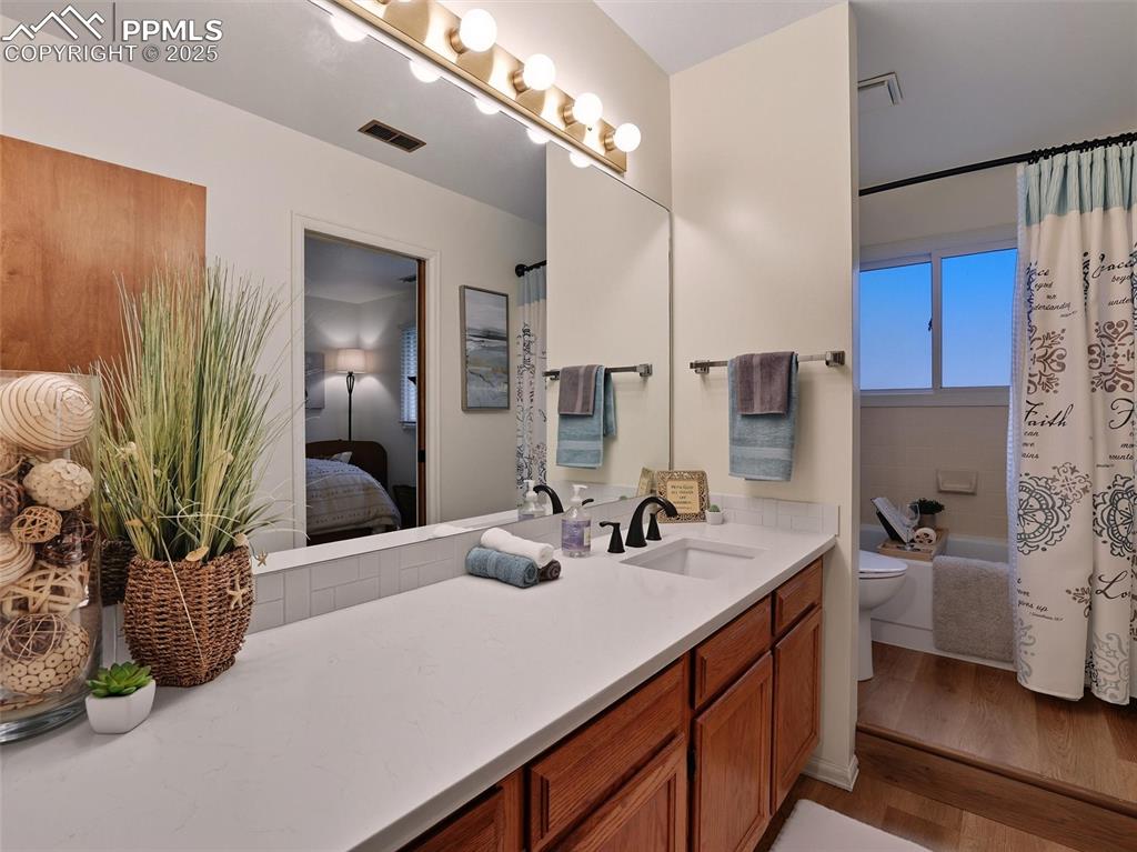 Image 30 of 36: Hall bath with full tub/shower combo and quartz counters.