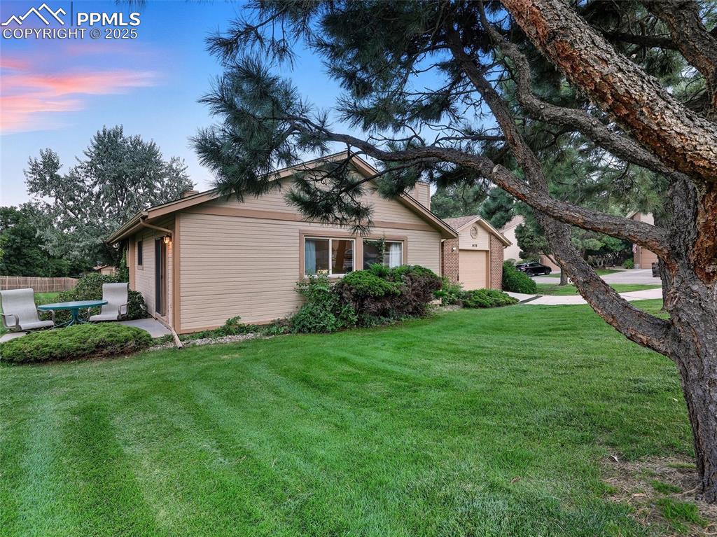 Image 33 of 36: Open grassy area continues around to the front of the home
