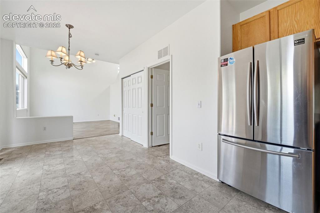 Image 10 of 48: Kitchen area featuring tile flooring, stainless steel refrigerator, and woo