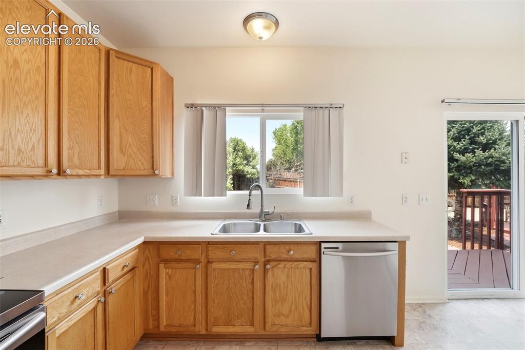 Image 13 of 48: Kitchen featuring light wood cabinetry, a dual-basin stainless steel sink, 