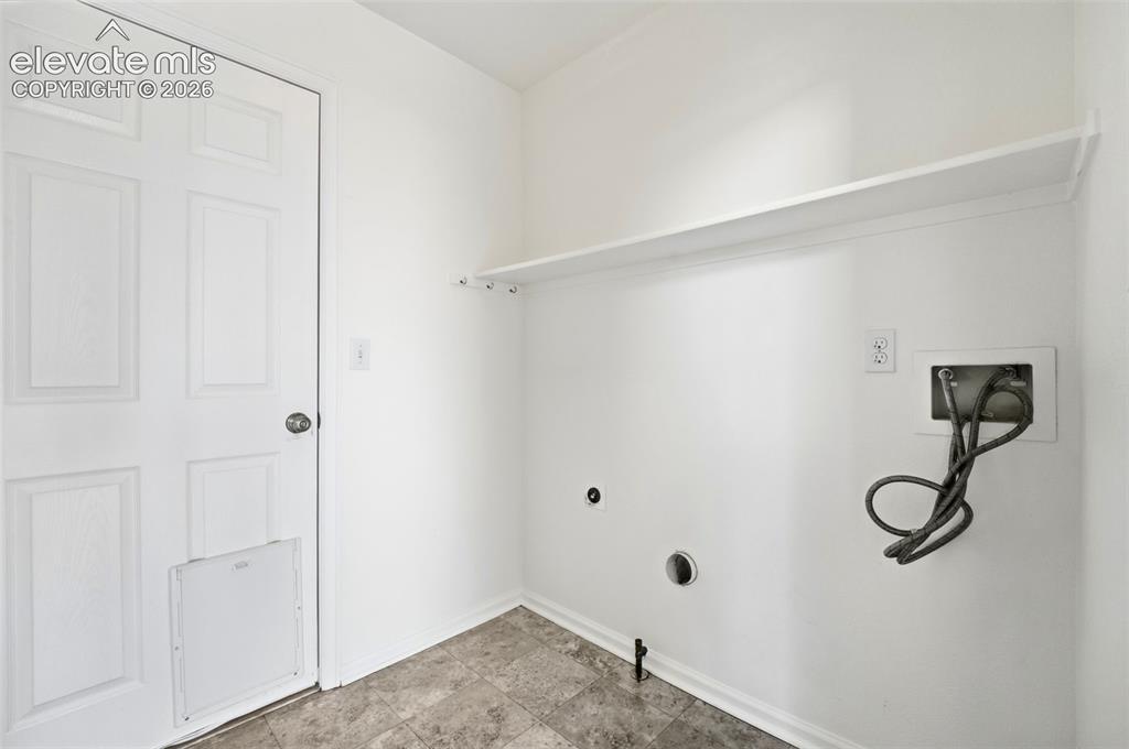Image 16 of 48: Utility area featuring a paneled door, wall-mounted shelving, and utility h