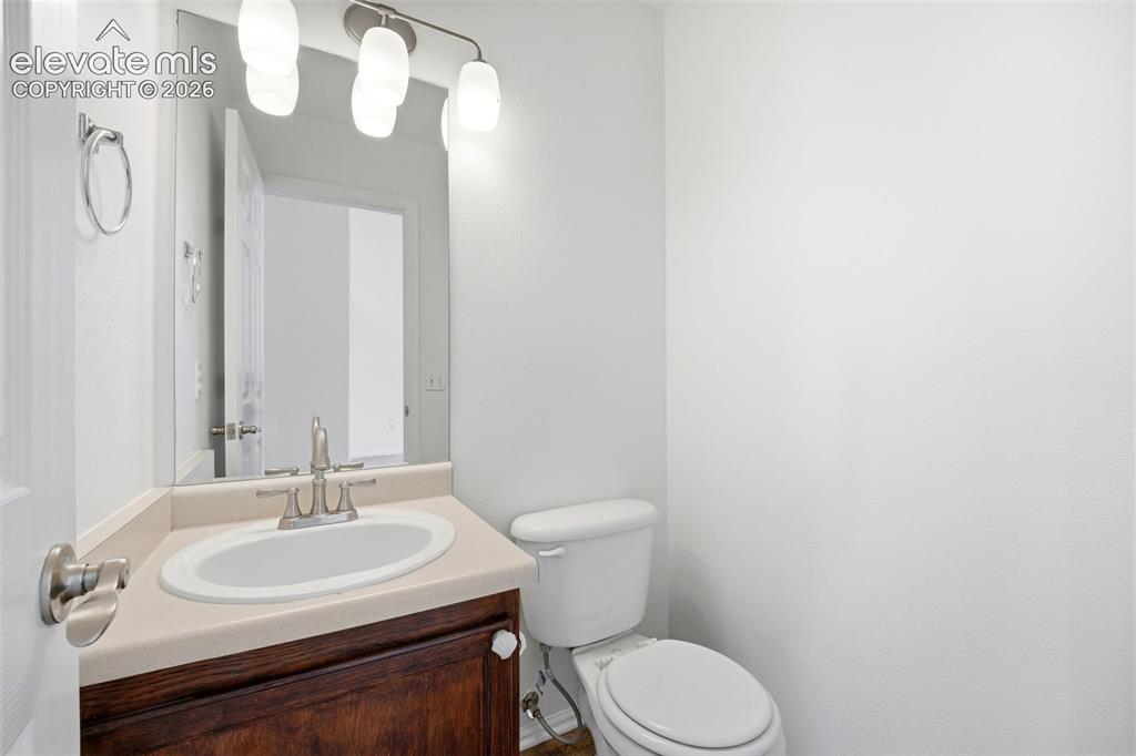 Image 17 of 48: Powder room featuring a dark wood vanity with white ceramic sink, light-ton