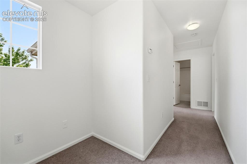 Image 18 of 48: Neutral-toned carpet flooring extends throughout this interior space with w