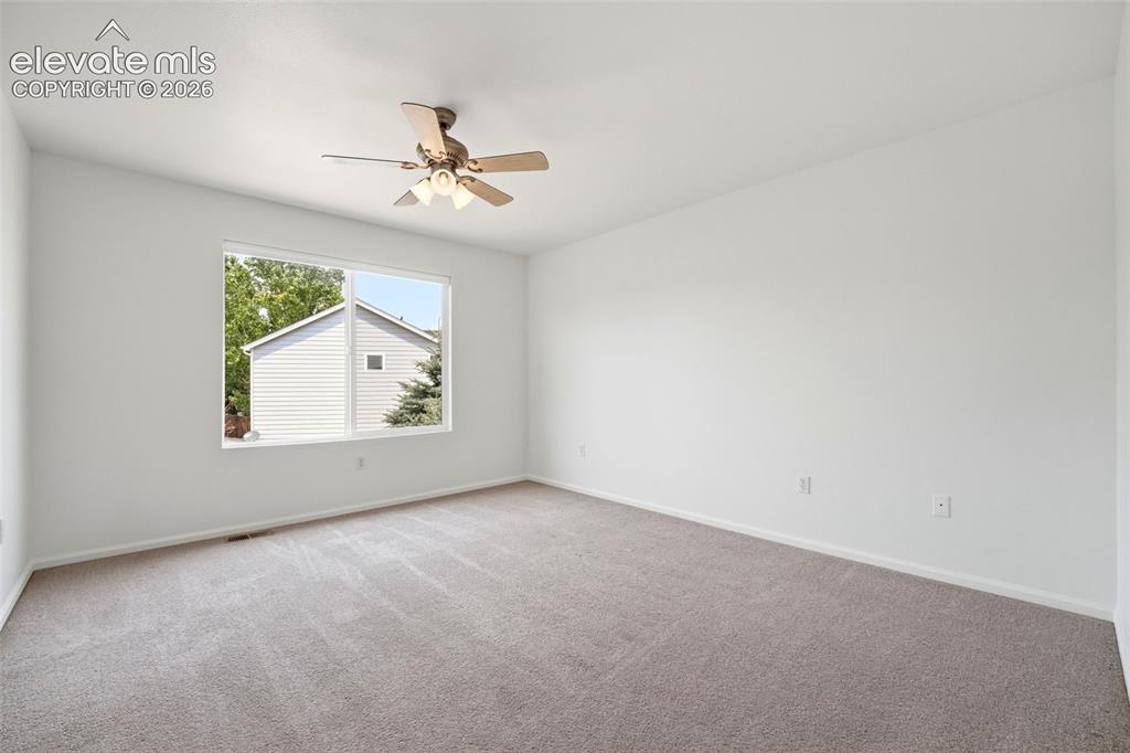 Image 20 of 48: Bright interior space featuring a large window, neutral paint, and carpet f