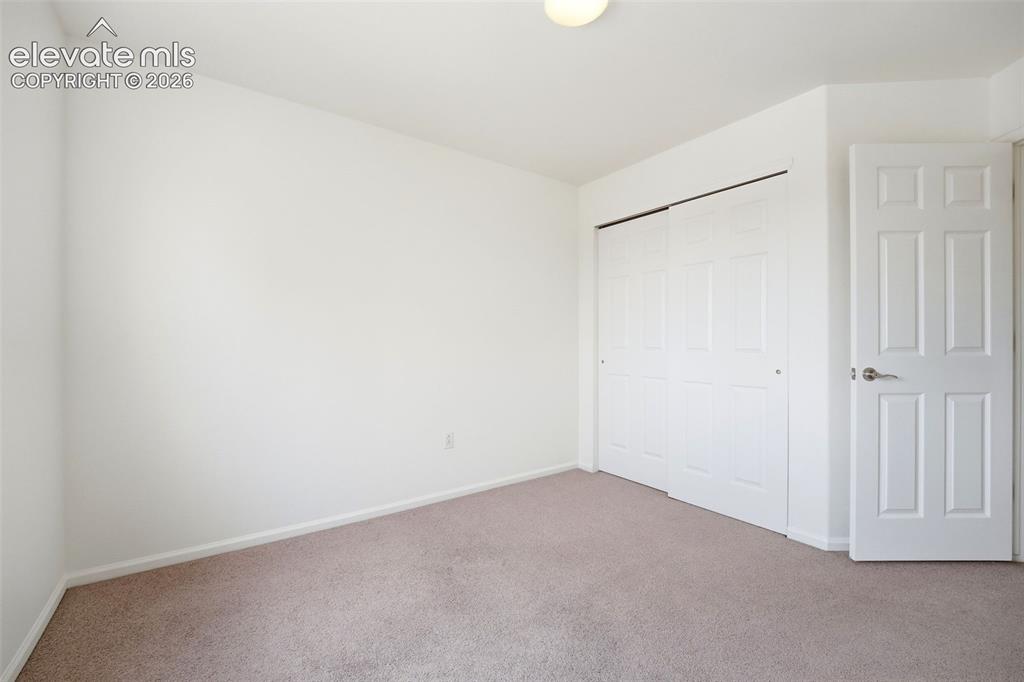 Image 26 of 48: Light-colored carpeting complementing white walls, featuring a bi-fold clos