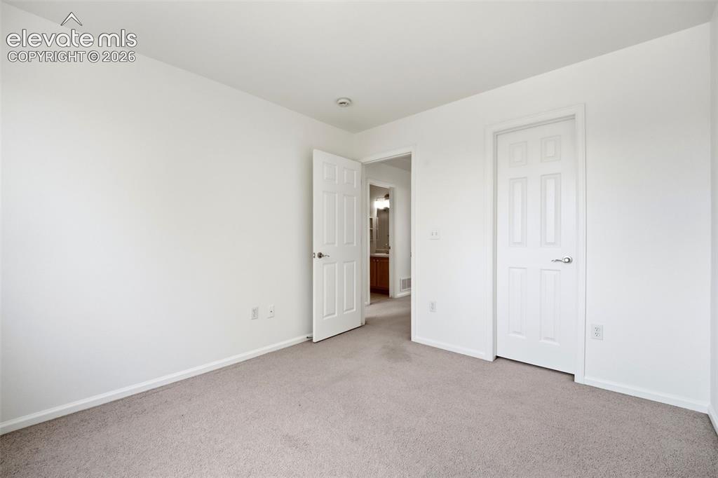 Image 30 of 48: Carpeted room featuring white walls, white baseboards, and two white panele
