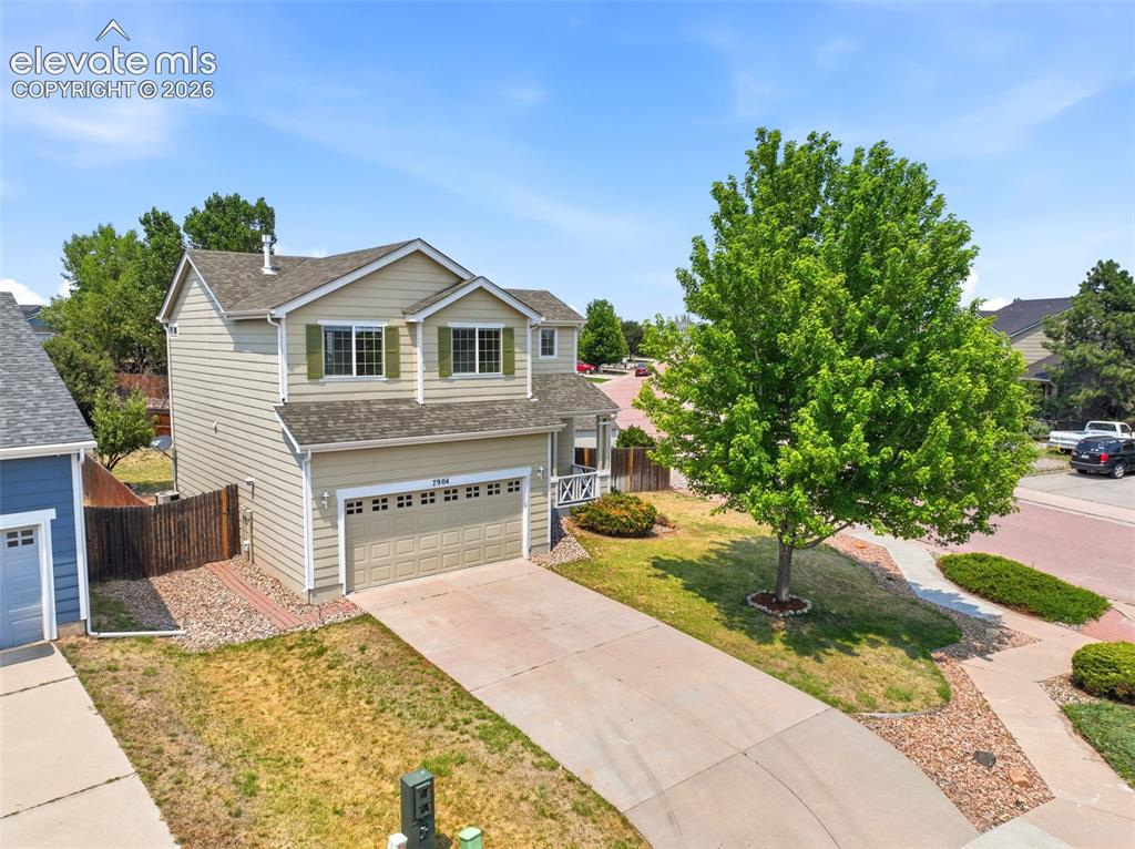 Image 38 of 48: Two-story residence featuring light beige siding and a two-car garage