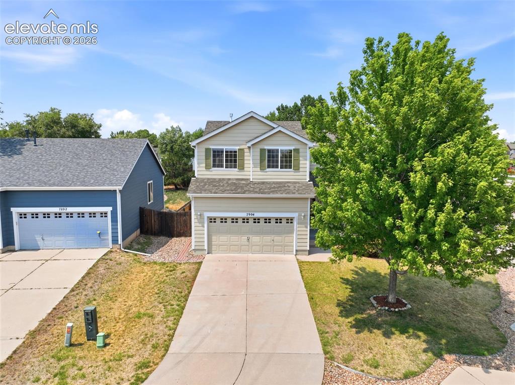 Image 39 of 48: Two-story residence featuring a two-car garage with panel detailing, light 