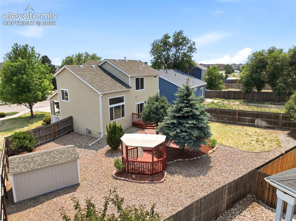 Image 40 of 48: Rear exterior featuring two-story construction, a spacious wooden deck, a g