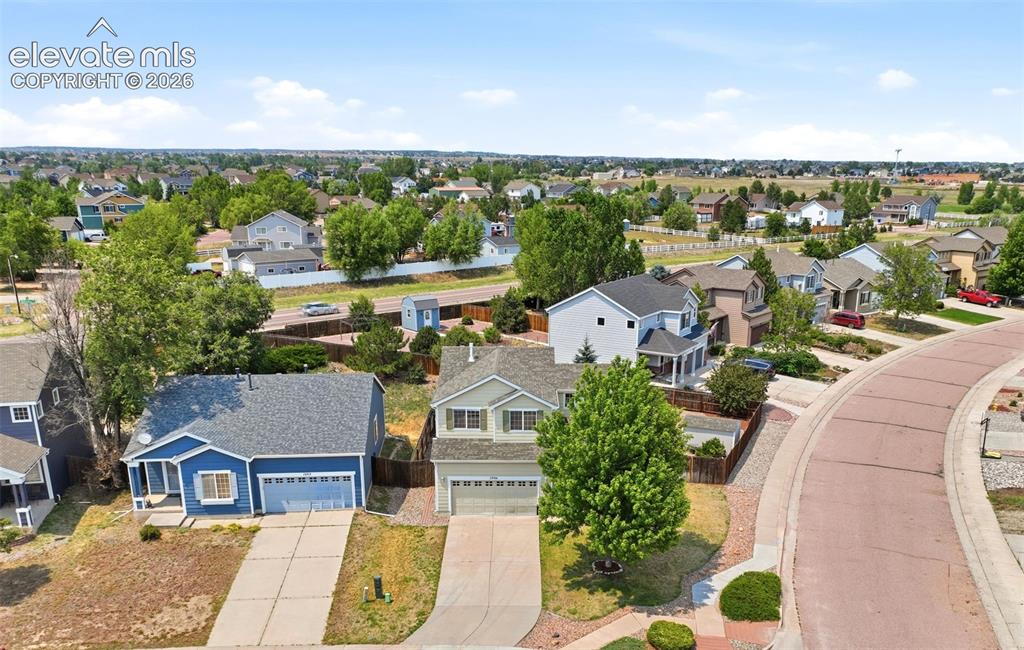 Image 45 of 48: Suburban streetscape featuring a curved brick-patterned road