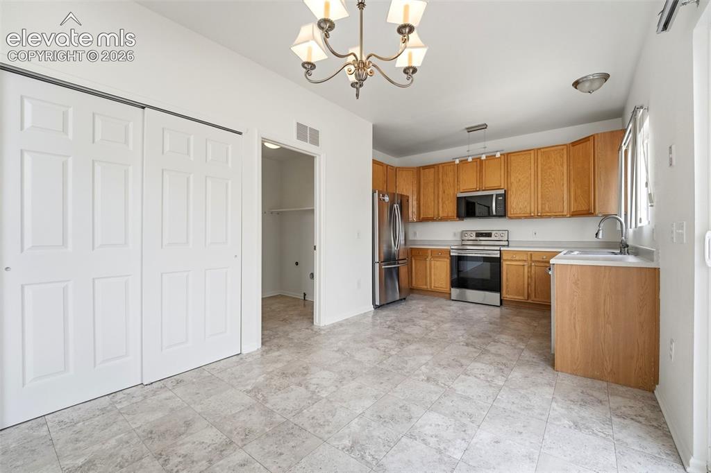 Image 7 of 48: Kitchen featuring wood cabinetry, stainless steel appliances, and a double 