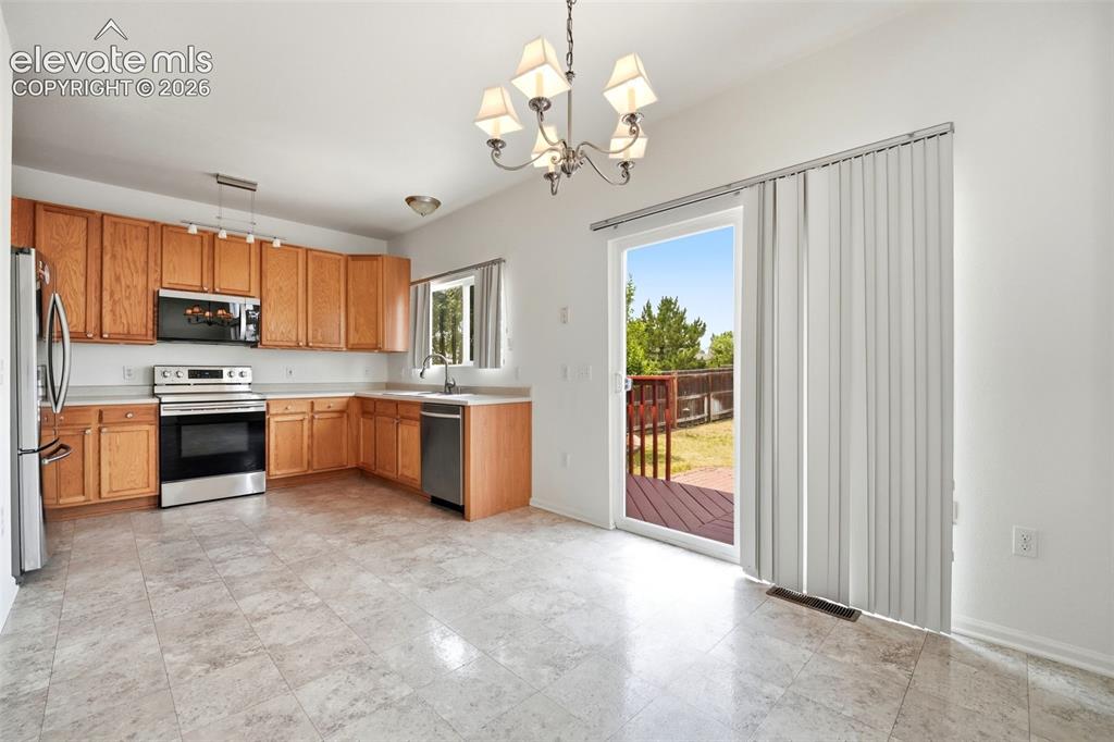Image 8 of 48: Light-filled dining area with direct access to a private wood deck