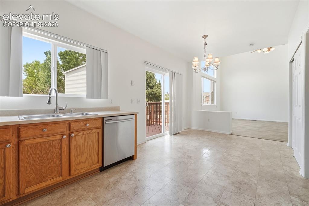 Image 9 of 48: Kitchen area featuring light wood cabinetry with round hardware, stainless 