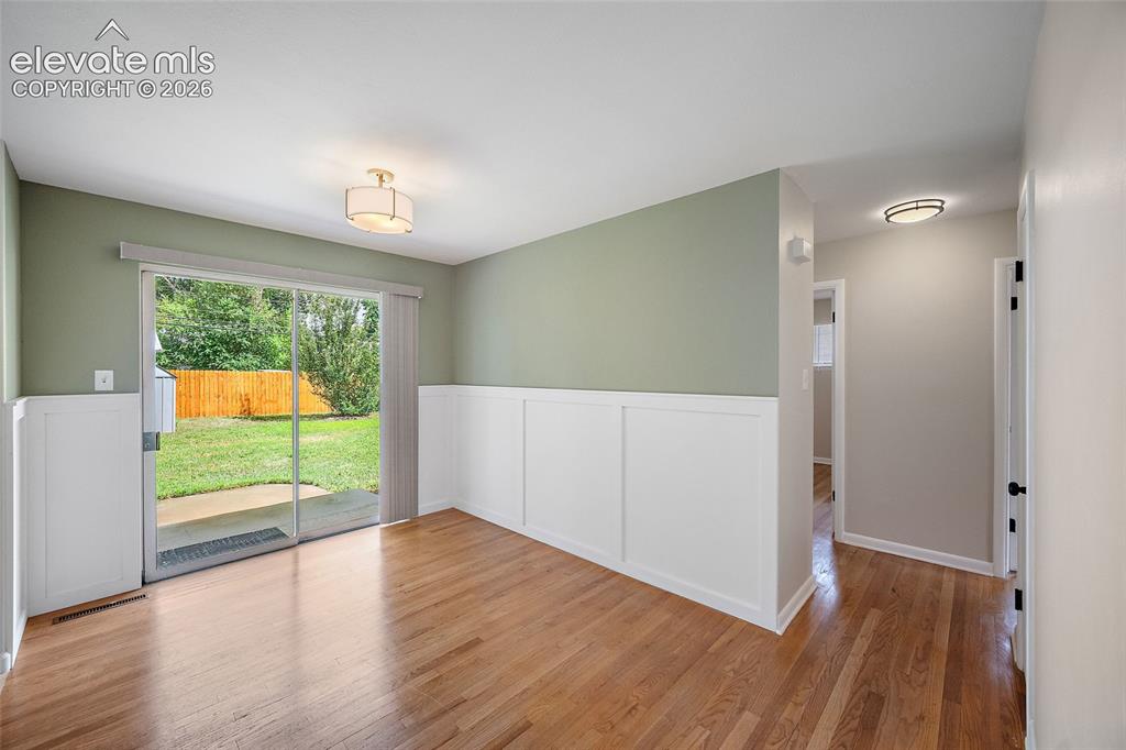 Image 10 of 43: Dining area with slider to backyard ( wain scotting)