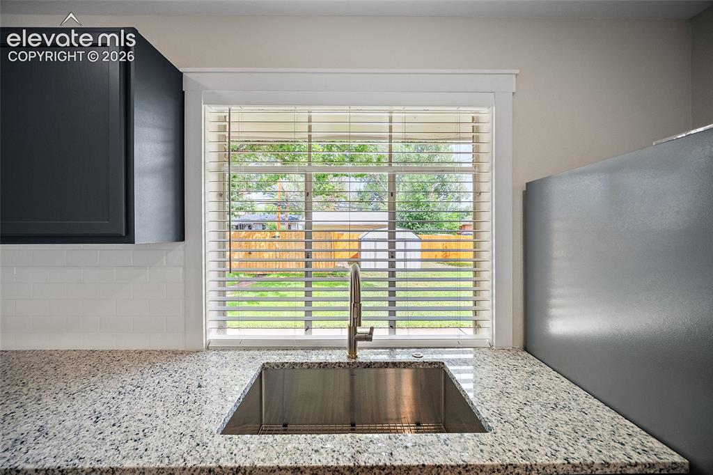 Image 15 of 43: Kitchen sink with view of backyard
