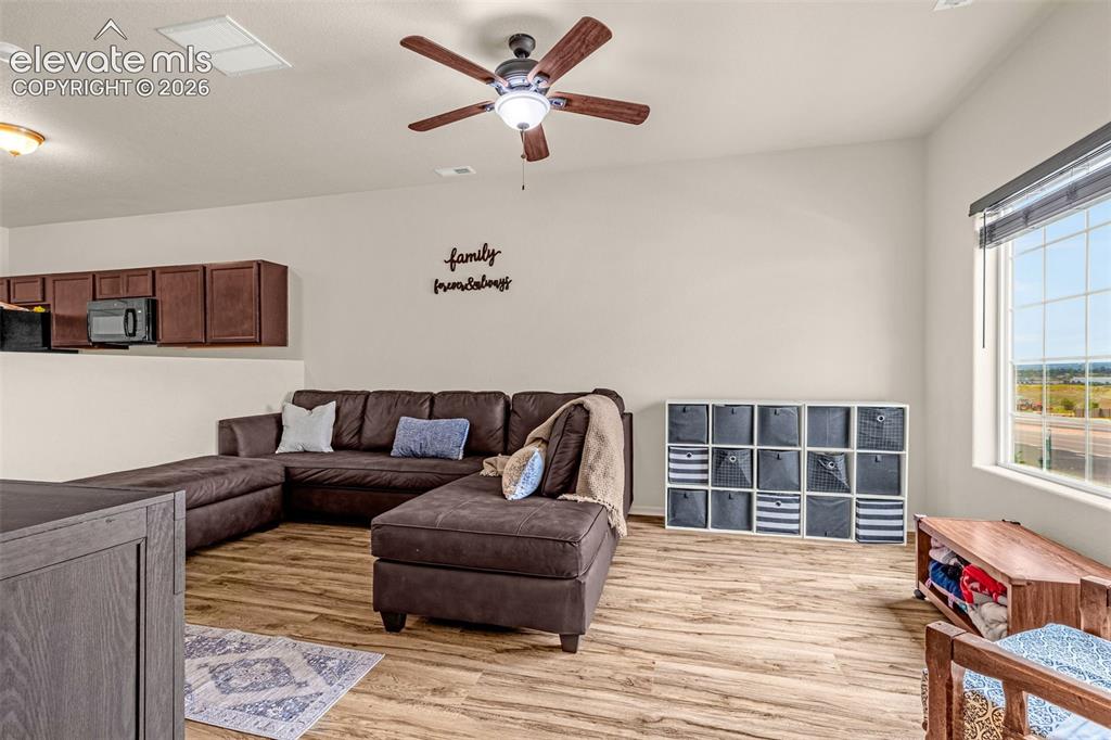 Image 11 of 38: Open-concept living space featuring wood-finish flooring, a ceiling fan wit