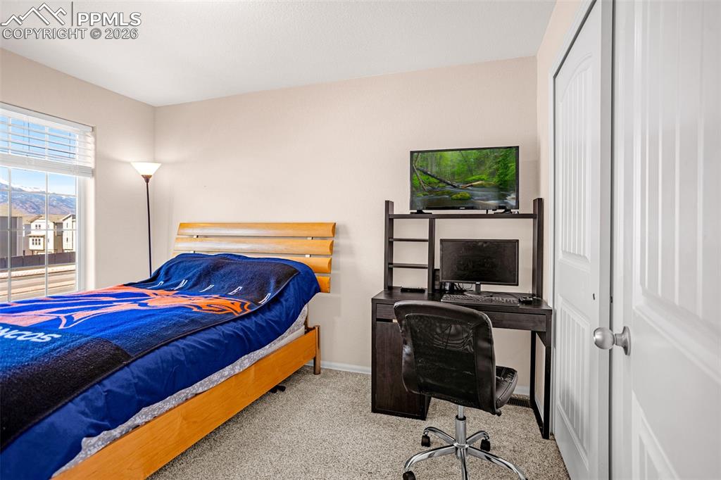 Image 13 of 30: Bedroom with a closet, light colored carpet, and a desk