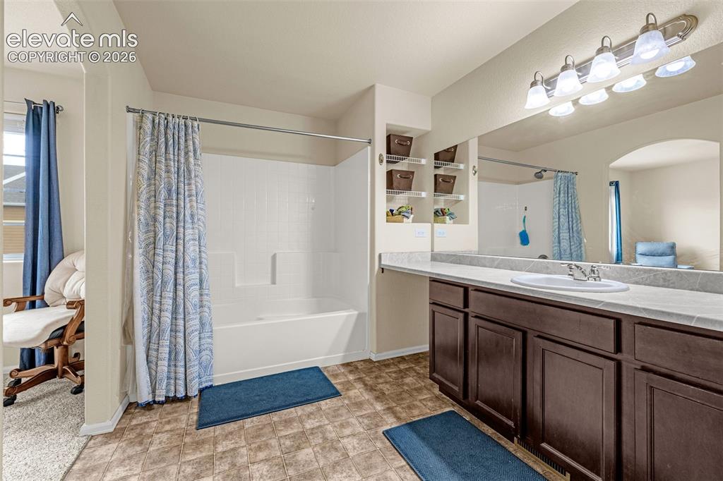 Image 17 of 38: Full bathroom featuring a white tub/shower combination, an extended vanity