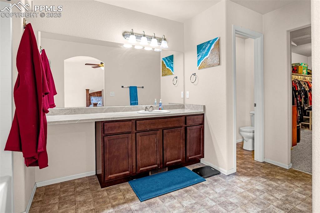 Image 19 of 30: Full bath featuring vanity, a walk in closet, and ceiling fan