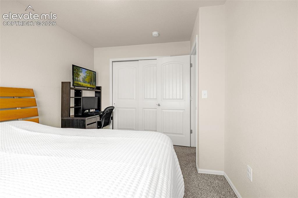 Image 22 of 38: Interior space with light-toned walls and grey textured carpeting