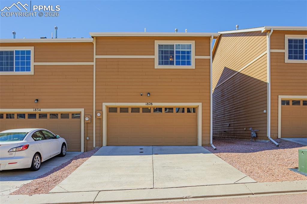 Image 28 of 30: View of front of property with concrete driveway and an attached garage