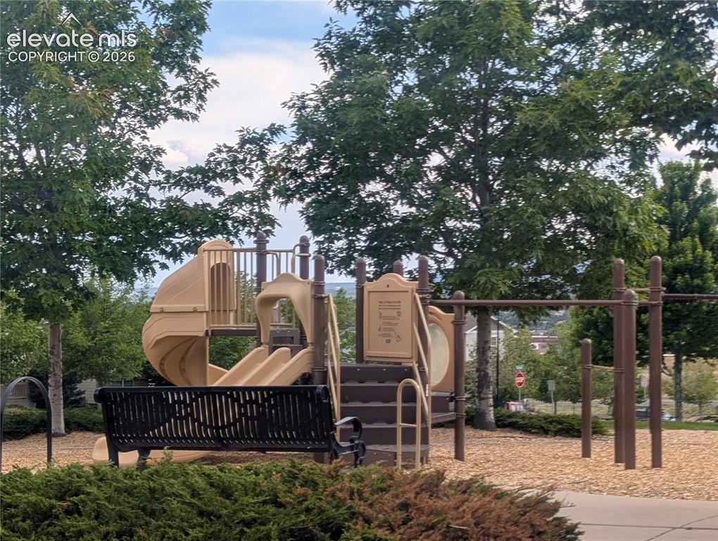 Image 28 of 38: Outdoor recreational area featuring a playground structure with multiple sl