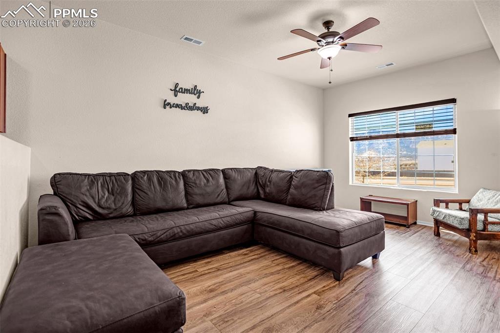 Image 6 of 30: Living room featuring wood finished floors and a ceiling fan