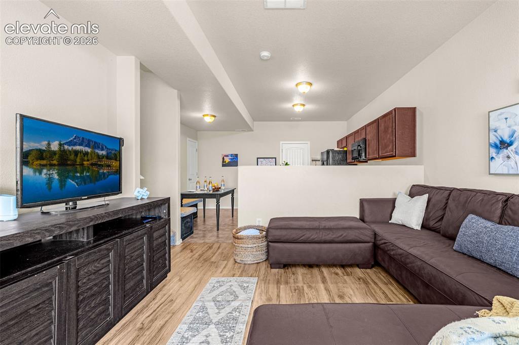 Image 9 of 38: Expansive open-concept room featuring wood-finish flooring, recessed lighti