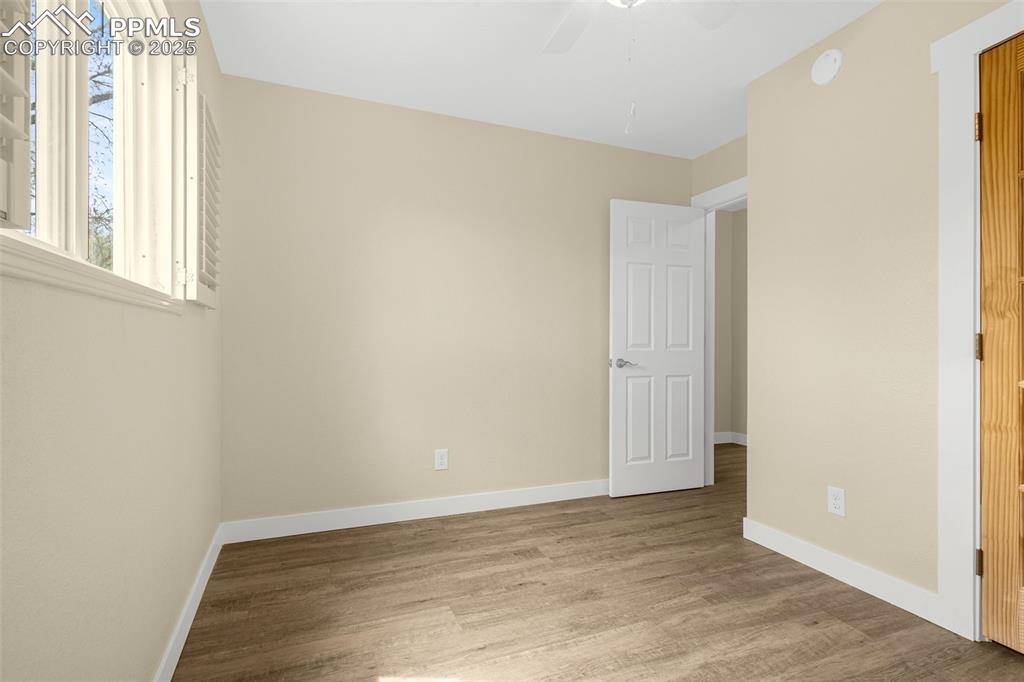 Image 12 of 36: Unfurnished bedroom with wood finished floors, ceiling fan, and baseboards