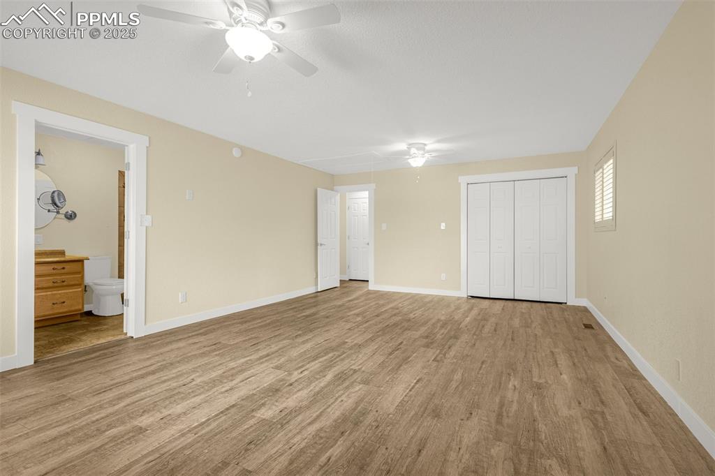 Image 16 of 36: Unfurnished bedroom with wood finished floors, a closet, ensuite bathroom, 