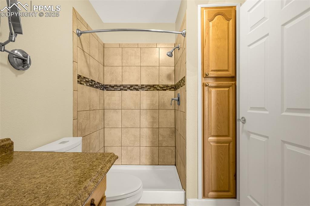 Image 19 of 36: Full bath featuring vanity, toilet, and a stall shower