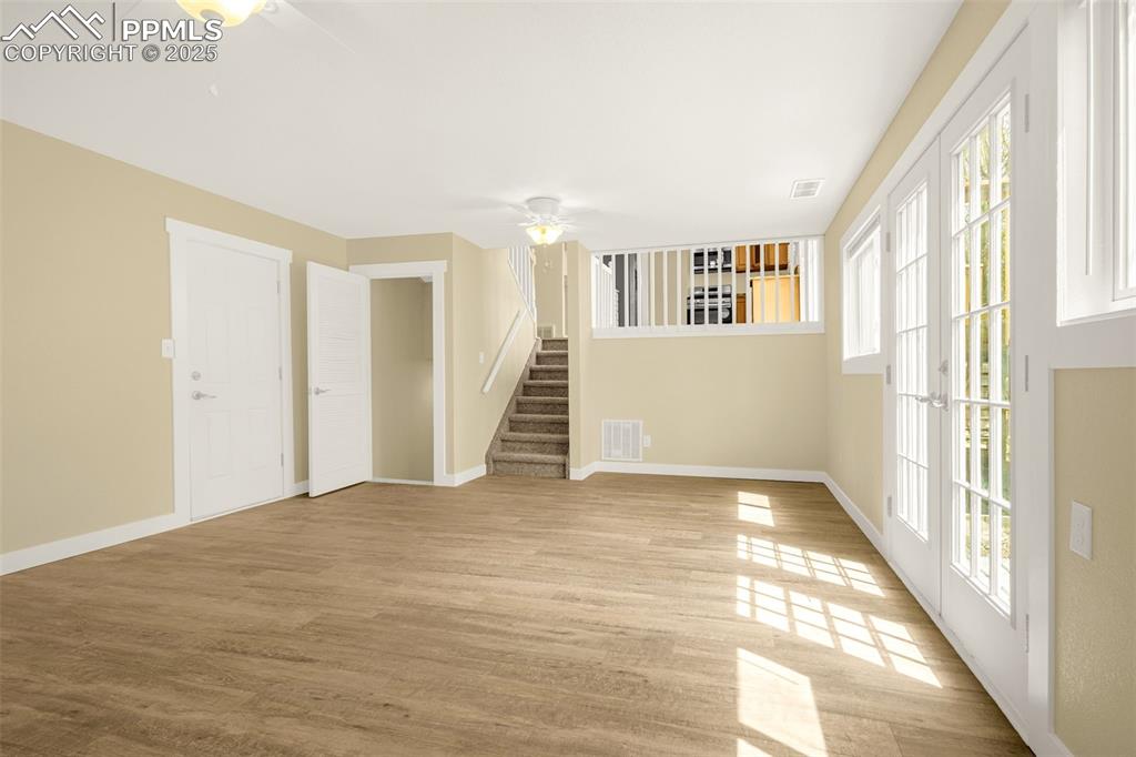 Image 23 of 36: Empty room featuring stairs, light wood-type flooring, baseboards, visible 